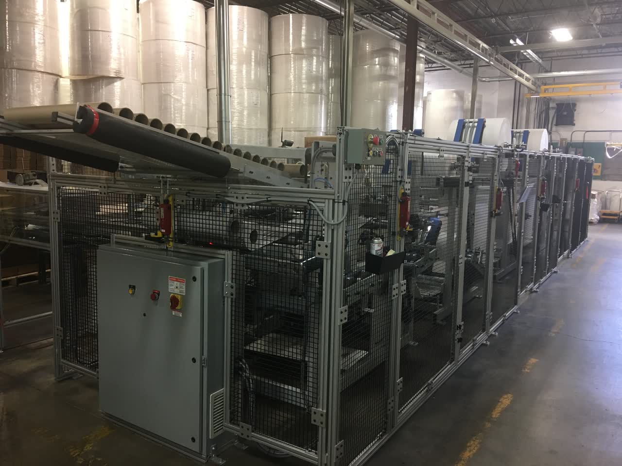 Large unwind and rewind system with guarding installed on a factory floor